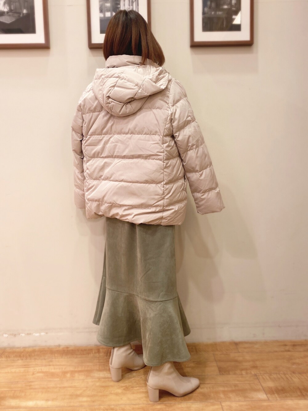 グリーン系のニット/セーター、グリーン系のスカート、ホワイト系のブーツを着用したレディースの冬コーディネートの2枚目の写真