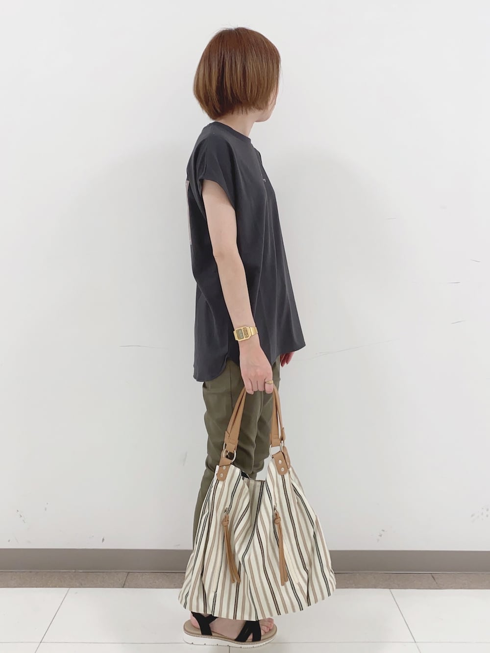 グレー系のTシャツ/カットソー、グリーン系のその他パンツ、ブラック系のサンダルを着用したレディースの春コーディネートの2枚目の写真