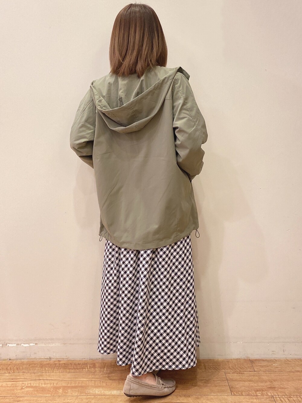 ホワイト系のTシャツ/カットソー、グリーン系のブルゾン、ブラック系のスカートを着用したレディースの春コーディネートの3枚目の写真