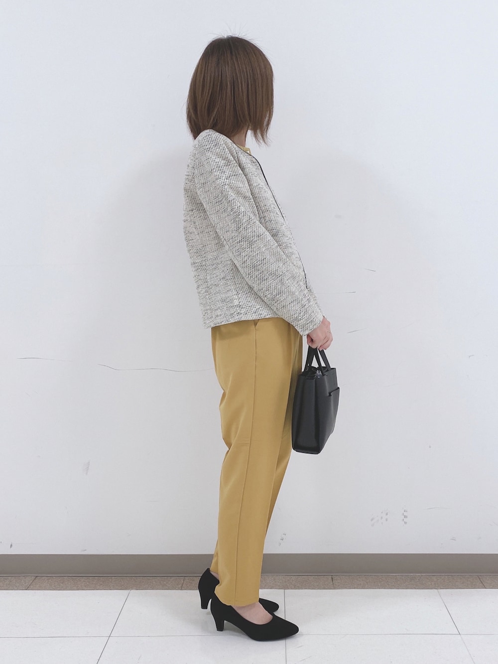 グレー系のノーカラージャケット、イエロー系のシャツ/ブラウス、イエロー系のその他パンツを着用したレディースの冬コーディネートの2枚目の写真