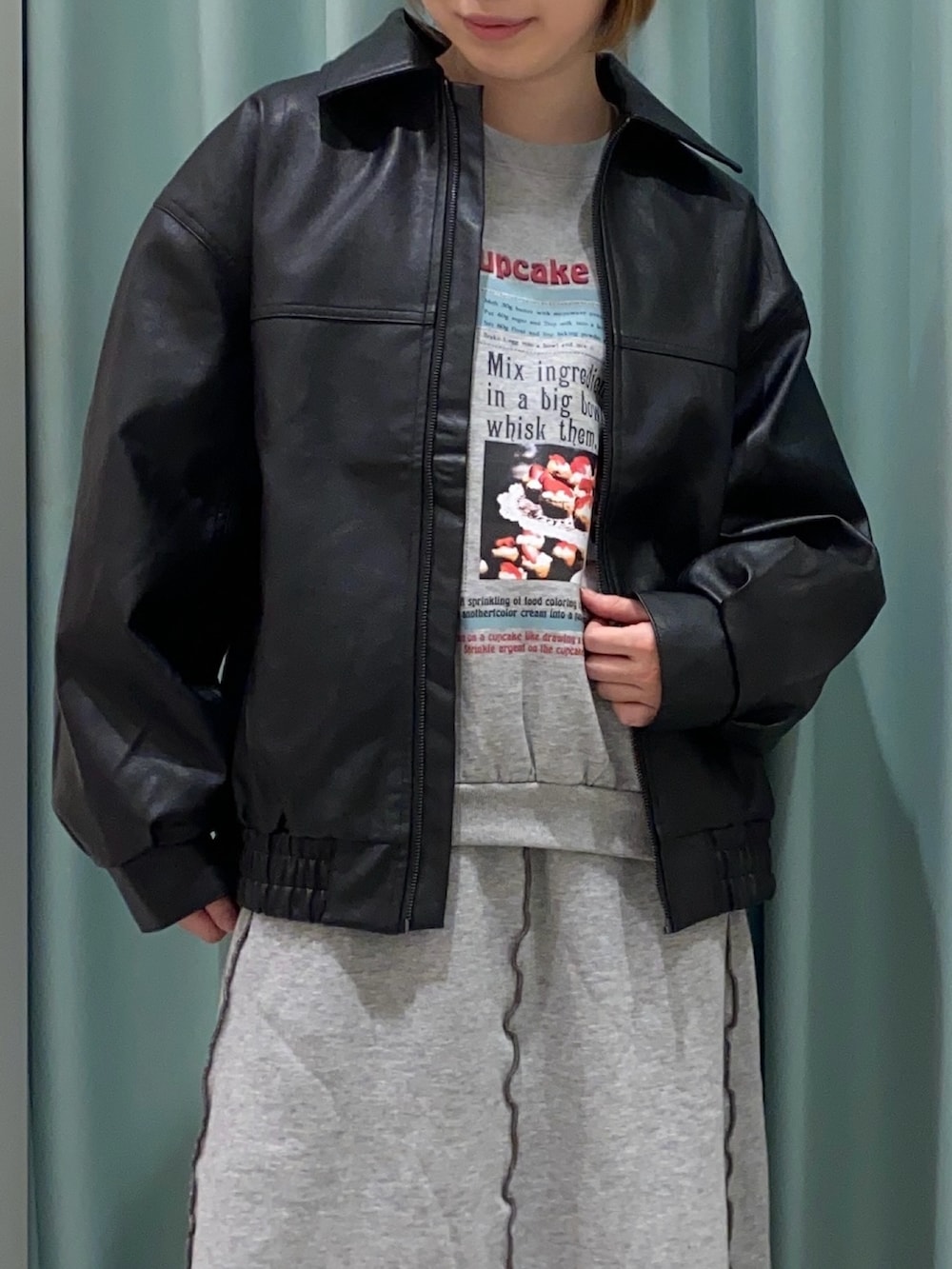 ブラック系のブルゾン、グレー系のスカート、ブラック系のブーツを着用したレディースの秋コーディネートの4枚目の写真