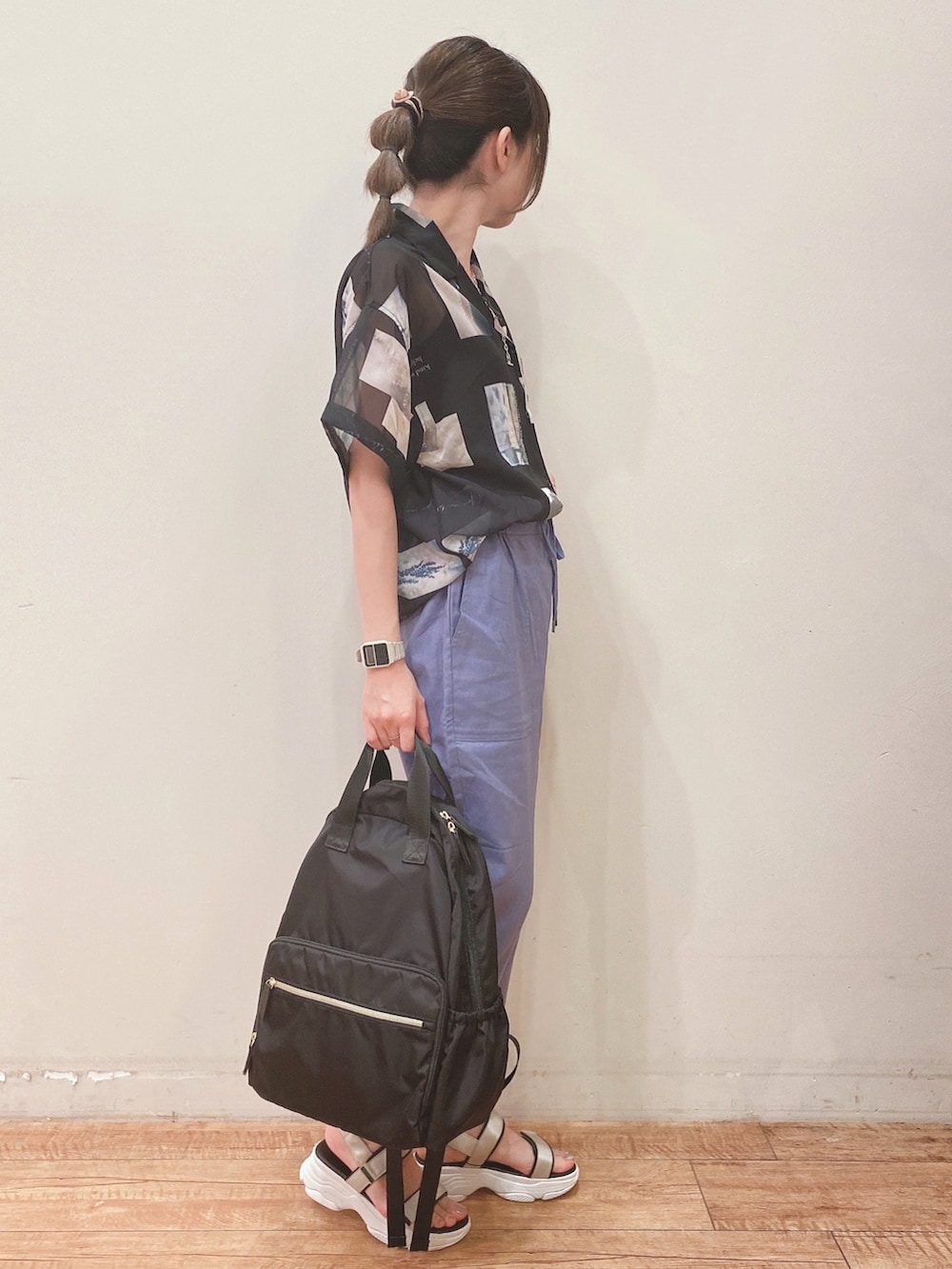 ブルー系のその他パンツ、ベージュ系のサンダル、ブラック系のバックパック/リュックを着用したレディースの春コーディネートの2枚目の写真