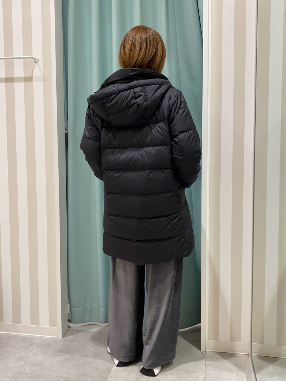 ブラック系のダウンジャケット/コート、ホワイト系のニット/セーター、グレー系のその他パンツを着用したレディースの秋コーディネートの3枚目の写真