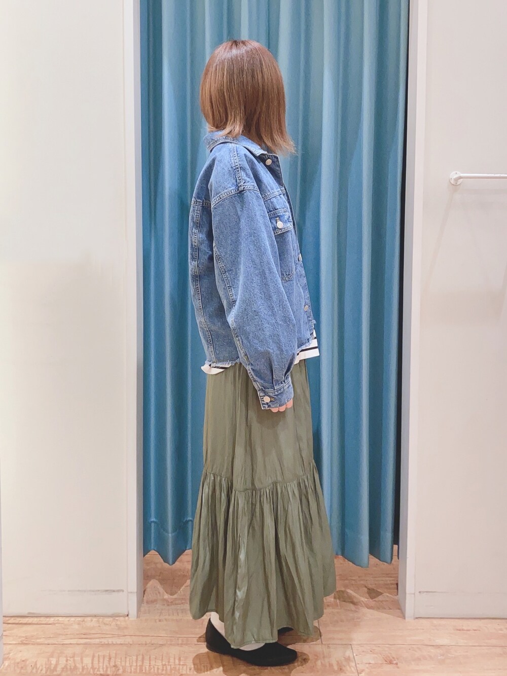 ブルー系のデニムジャケット、ブラック系のTシャツ/カットソー、グリーン系のスカートを着用したレディースの春コーディネートの2枚目の写真