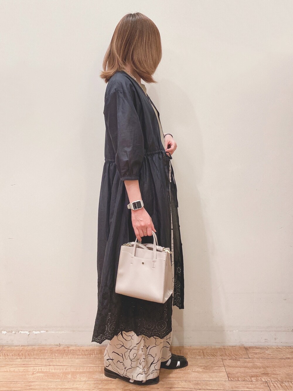 グリーン系のタンクトップ、ブラック系のワンピース、ベージュ系のその他パンツを着用したレディースの春コーディネートの2枚目の写真