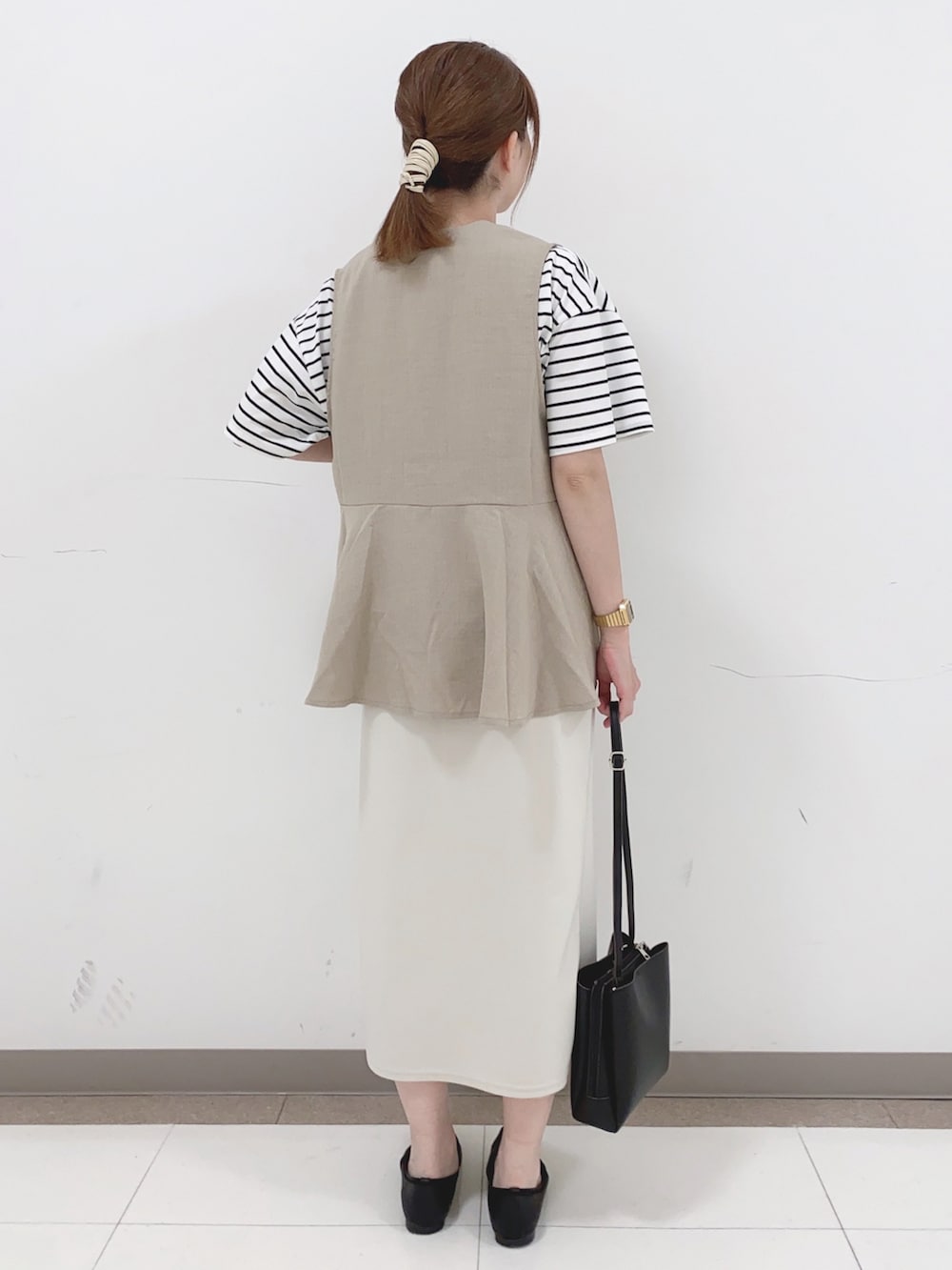 ベージュ系のベスト、ホワイト系のTシャツ/カットソー、ホワイト系のスカートを着用したレディースの春コーディネートの3枚目の写真