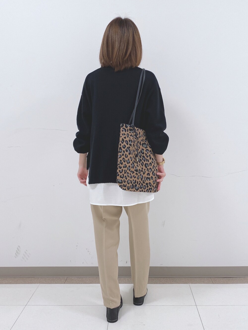 ブラック系のニット/セーター、ベージュ系のその他パンツ、ブラック系のスニーカーを着用したレディースの冬コーディネートの3枚目の写真