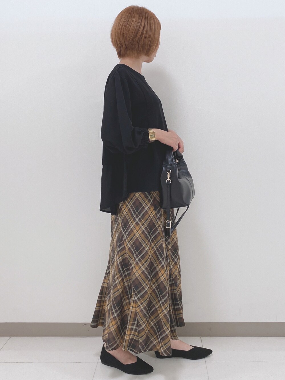 ブラック系のパンプス、ブラック系のトートバッグ、ブラック系のTシャツ/カットソーを着用したレディースの秋コーディネートの2枚目の写真