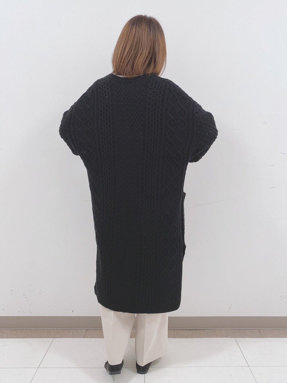 ベージュ系のニット/セーター、ベージュ系のその他パンツ、ブラック系のTシャツ/カットソーを着用したレディースの冬コーディネートの3枚目の写真