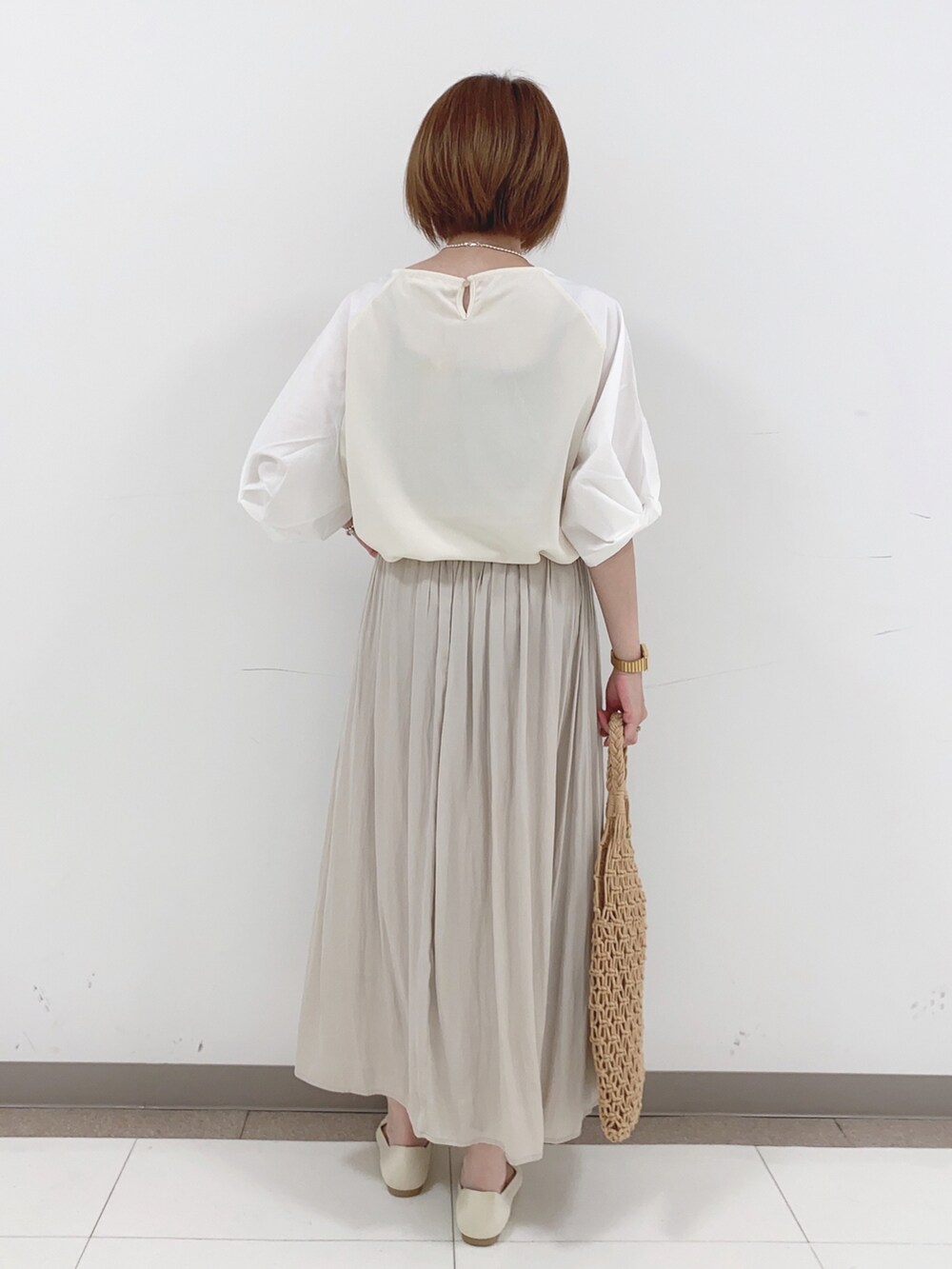 ベージュ系のTシャツ/カットソー、ベージュ系のパンプス、ブラウン系のトートバッグを着用したレディースの夏コーディネートの3枚目の写真