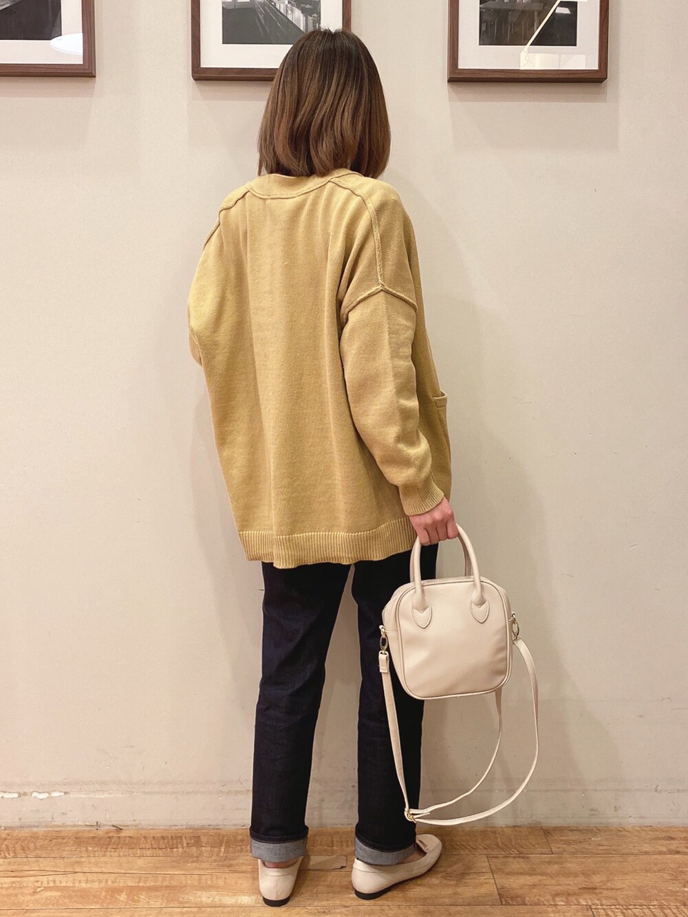 ホワイト系のドレスシューズ、ベージュ系のTシャツ/カットソー、イエロー系のカーディガン/ボレロを着用したレディースの冬コーディネートの2枚目の写真