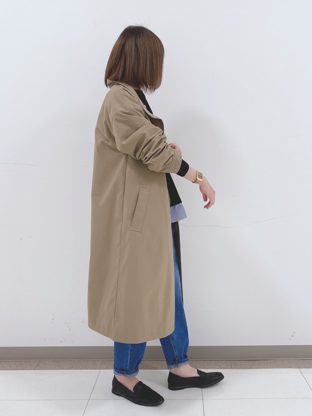 ブラック系のニット/セーター、ベージュ系のその他アウター、ブルー系のデニムパンツを着用したレディースの冬コーディネートの2枚目の写真