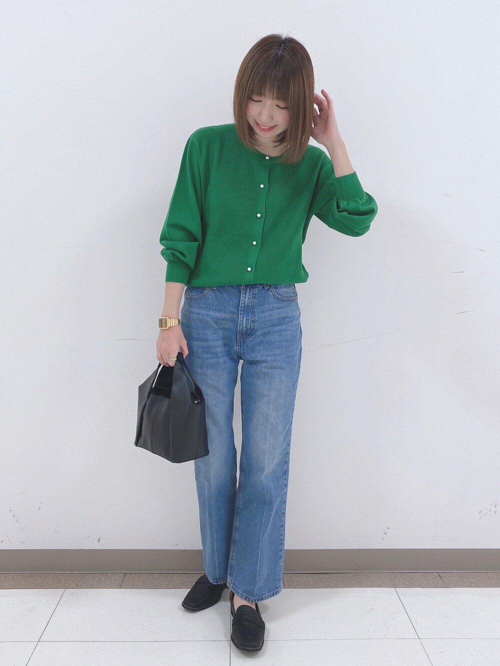 グリーン系のカーディガン/ボレロ、ブルー系のデニムパンツ、ブラック系のスニーカーを着用したレディースの冬コーディネートの4枚目の写真