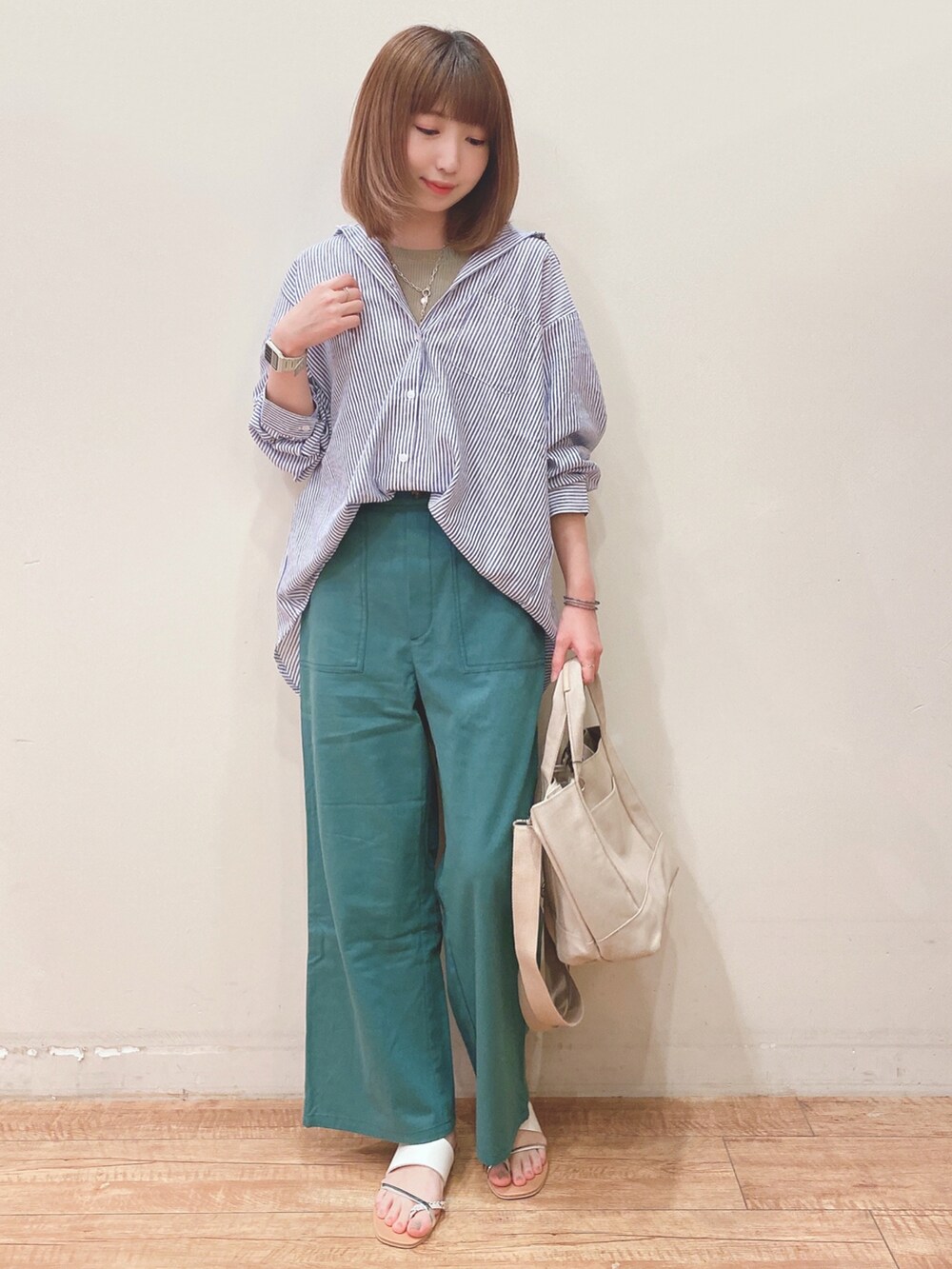 ブルー系のシャツ/ブラウス、グリーン系のその他パンツ、ベージュ系のトートバッグを着用したレディースの春コーディネートの4枚目の写真