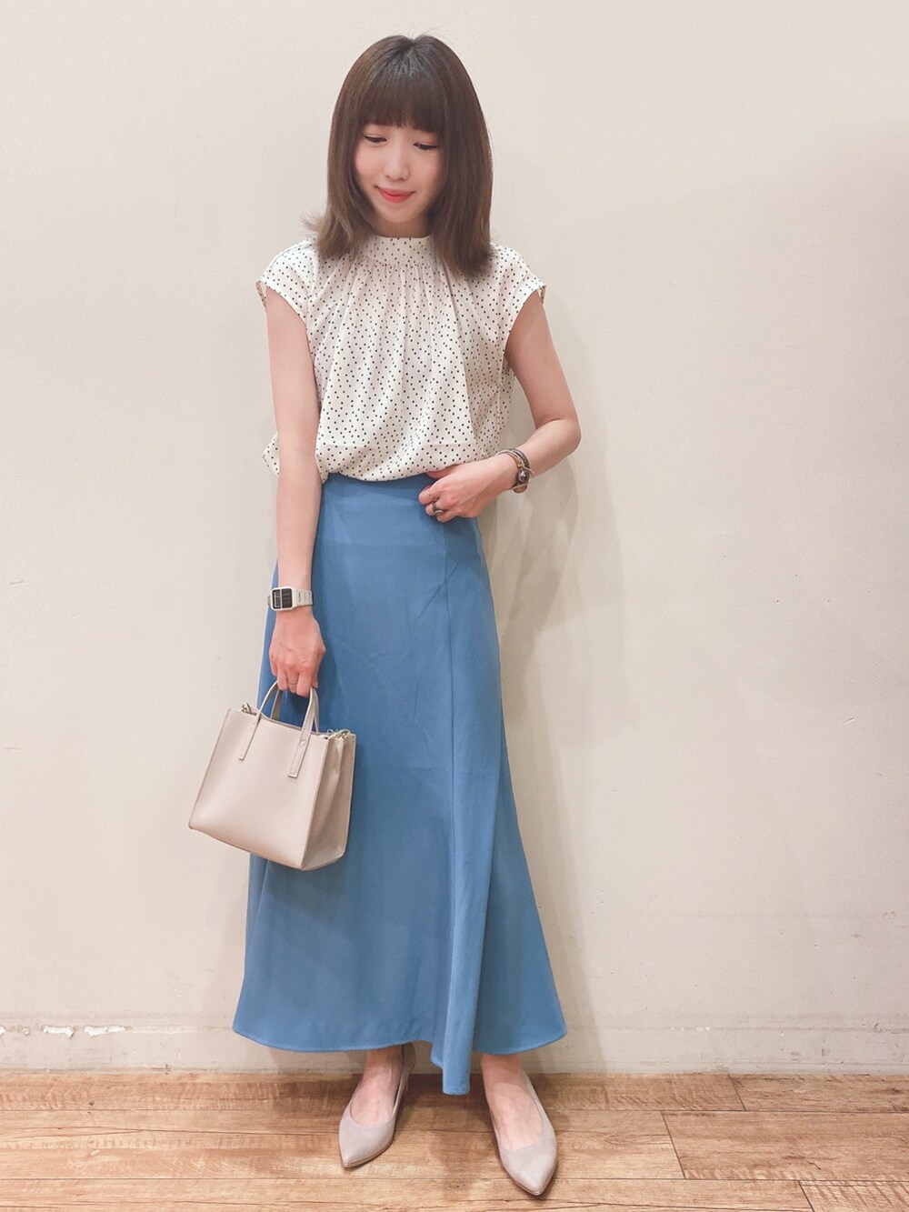 ベージュ系のシャツ/ブラウス、ブルー系のスカート、ベージュ系のパンプスを着用したレディースの春コーディネートの4枚目の写真