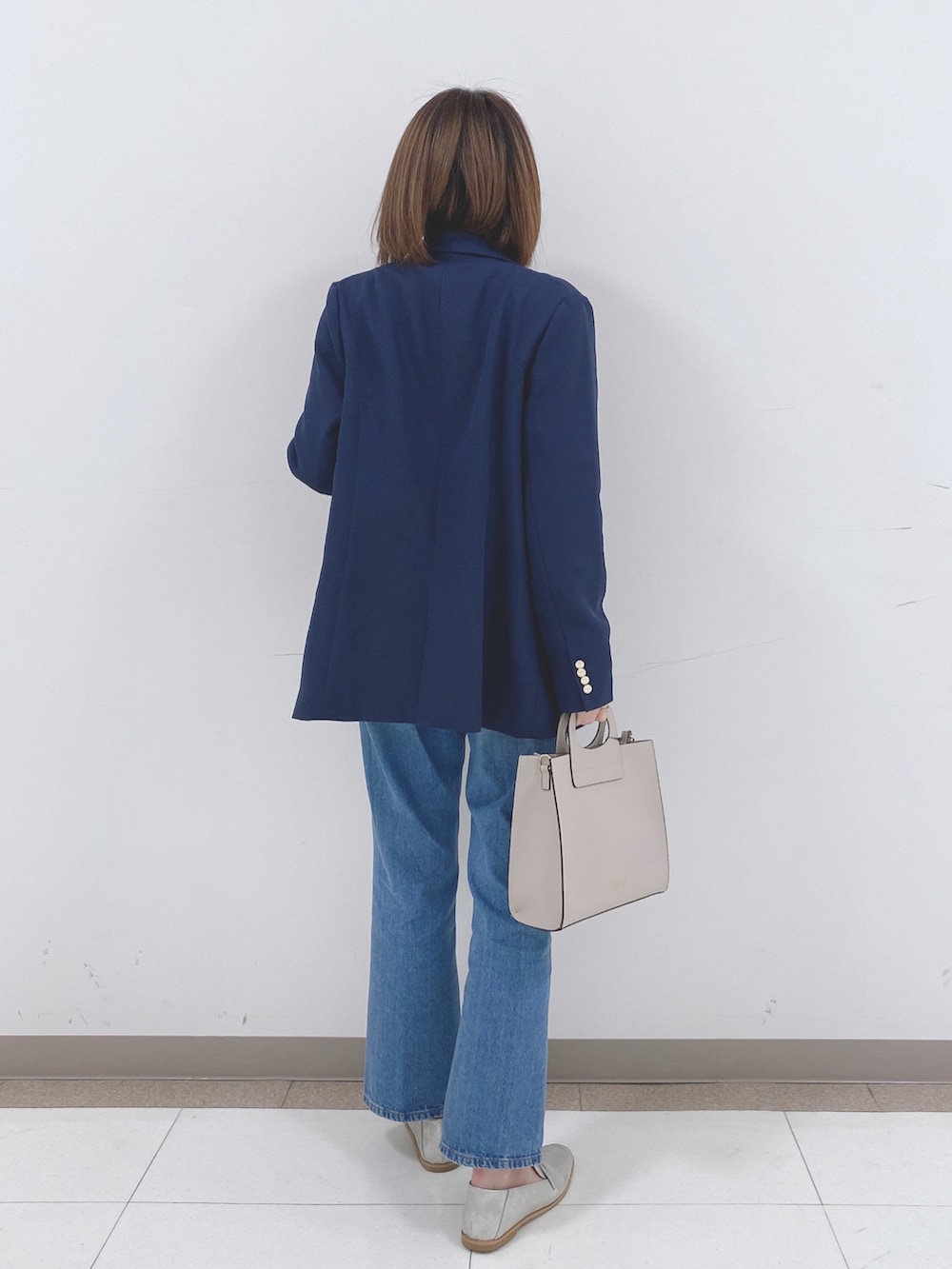 ベージュ系のニット/セーター、ブルー系のテーラードジャケット、ブルー系のデニムパンツを着用したレディースの冬コーディネートの3枚目の写真