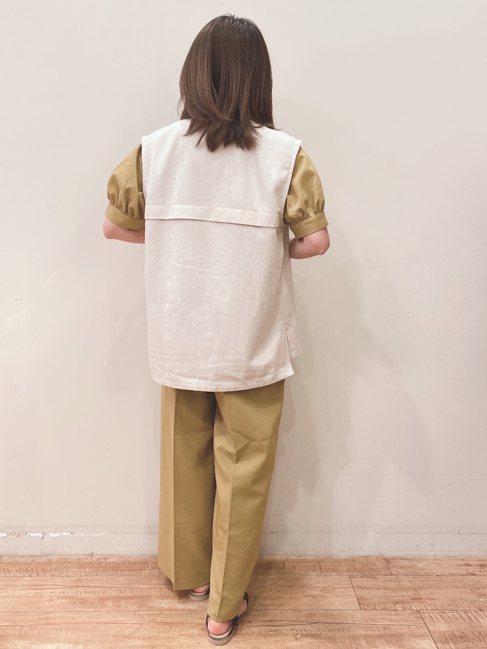 イエロー系のシャツ/ブラウス、イエロー系のその他パンツ、ベージュ系のベストを着用したレディースの春コーディネートの3枚目の写真