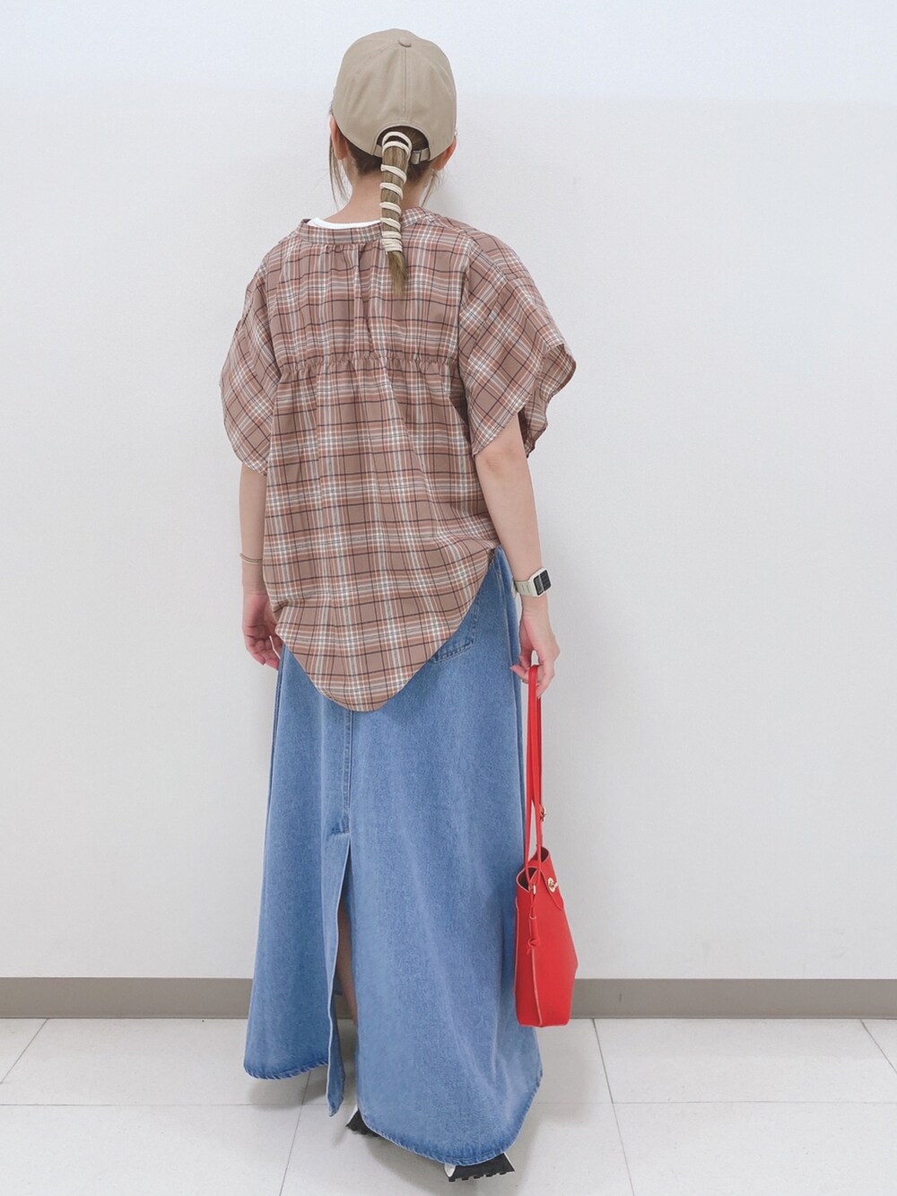 ベージュ系のシャツ/ブラウス、ブルー系のスカート、ベージュ系のスニーカーを着用したレディースの夏コーディネートの2枚目の写真