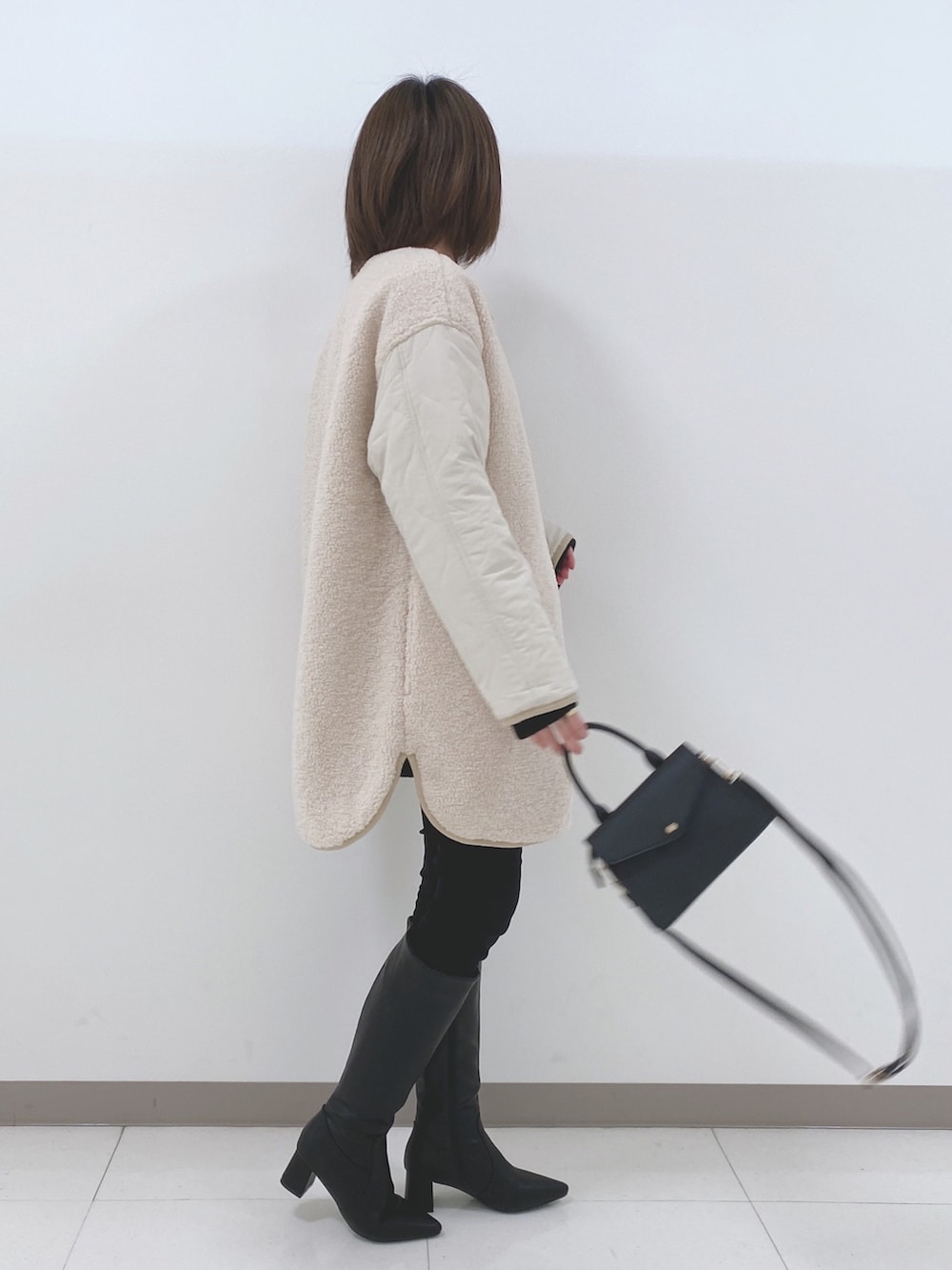 ベージュ系のノーカラージャケット、ブラック系のニット/セーター、ブラック系のその他パンツを着用したレディースの冬コーディネートの2枚目の写真