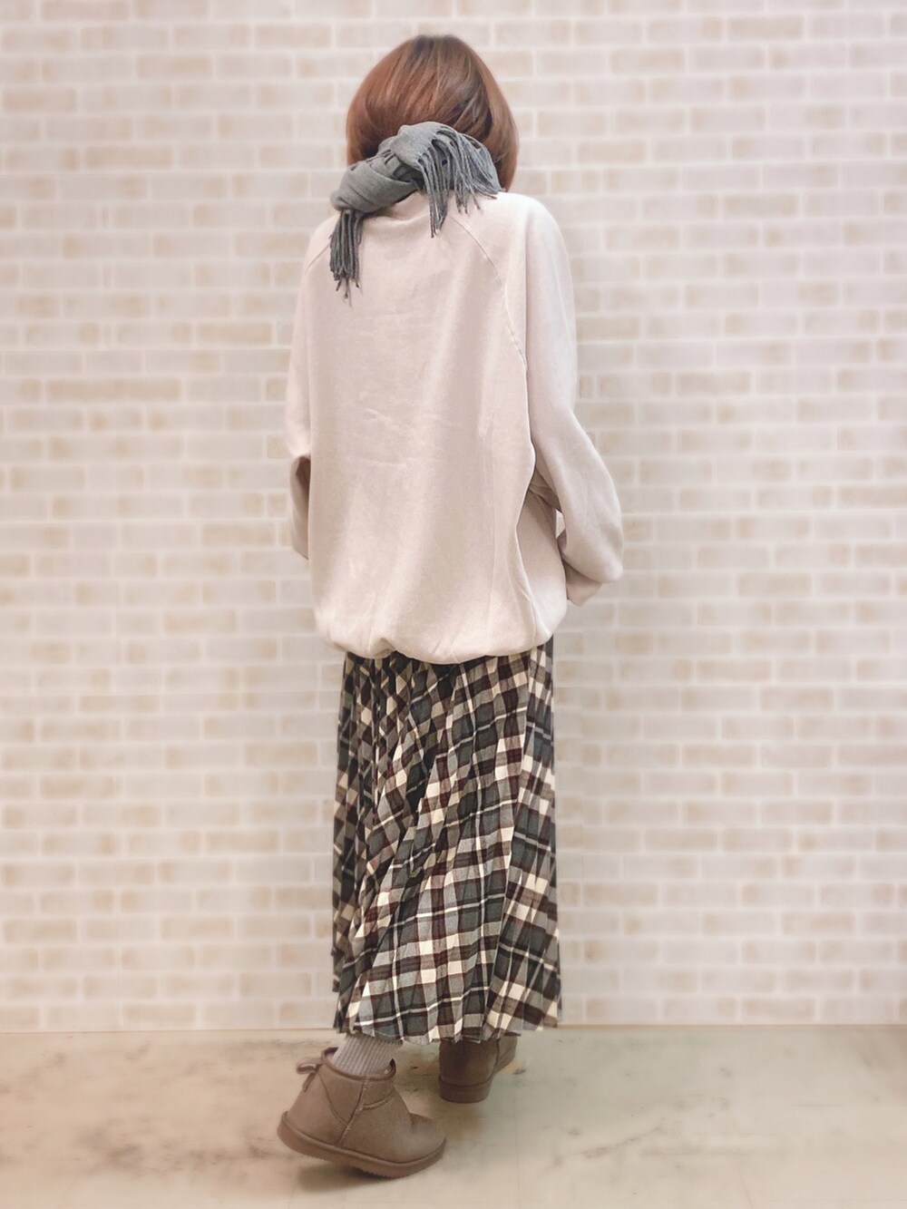 ベージュ系のスウェット、レッド系のスカート、ベージュ系のブーツを着用したレディースの冬コーディネートの2枚目の写真