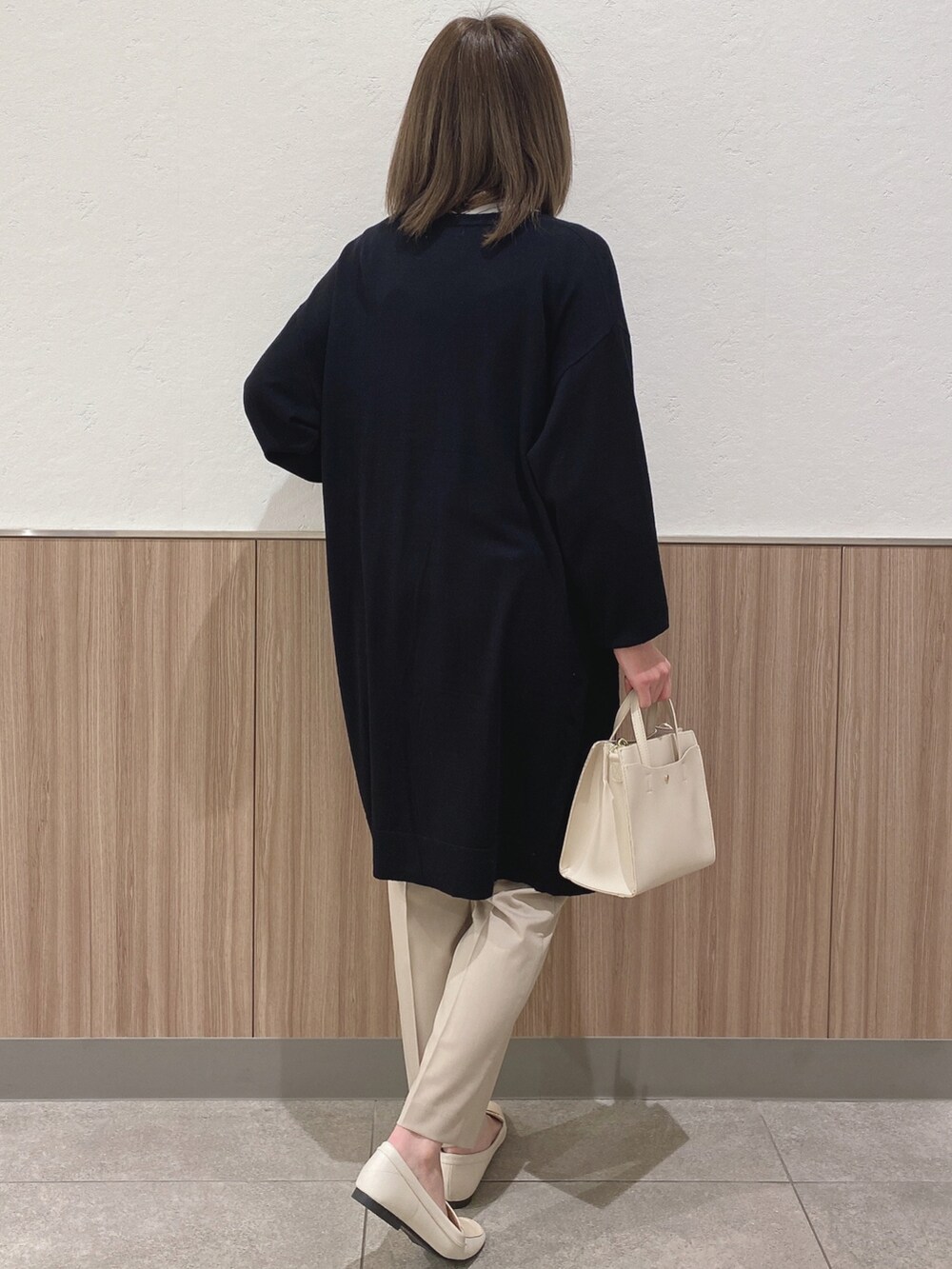 グリーン系のシャツ/ブラウス、ホワイト系のショルダーバッグ、ベージュ系のパンツを着用したレディースの春コーディネートの3枚目の写真