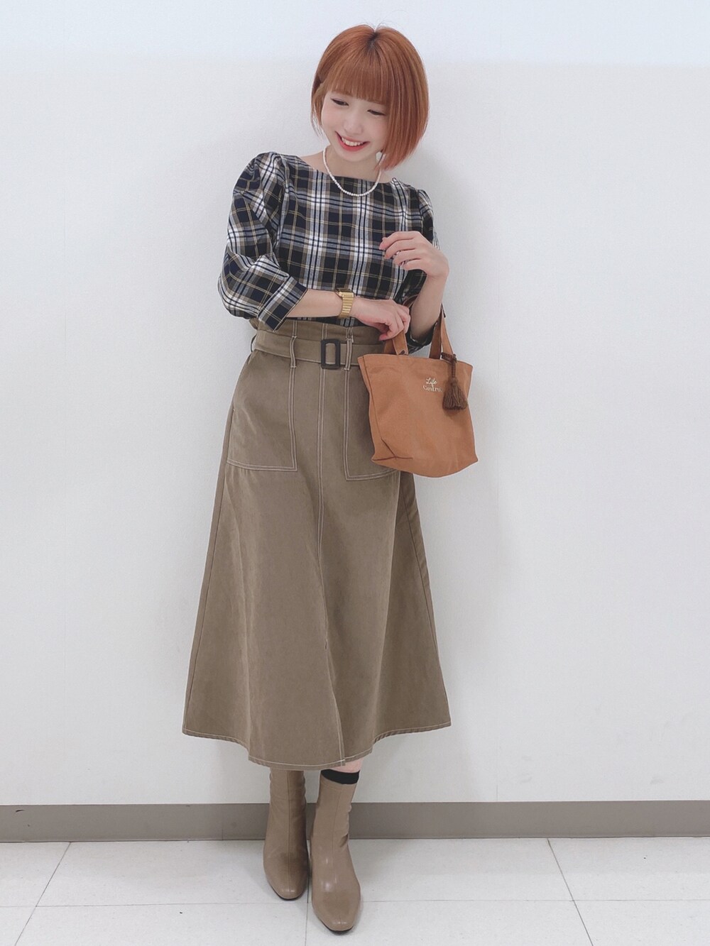 ブルー系のシャツ/ブラウス、ベージュ系のスカート、ベージュ系のブーツを着用したレディースの秋コーディネートの4枚目の写真