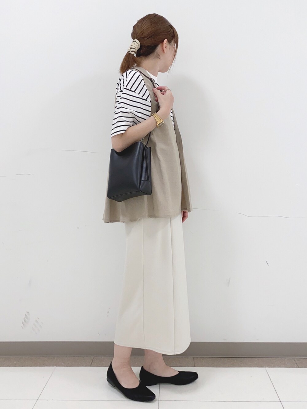 ベージュ系のベスト、ホワイト系のTシャツ/カットソー、ホワイト系のスカートを着用したレディースの春コーディネートの2枚目の写真