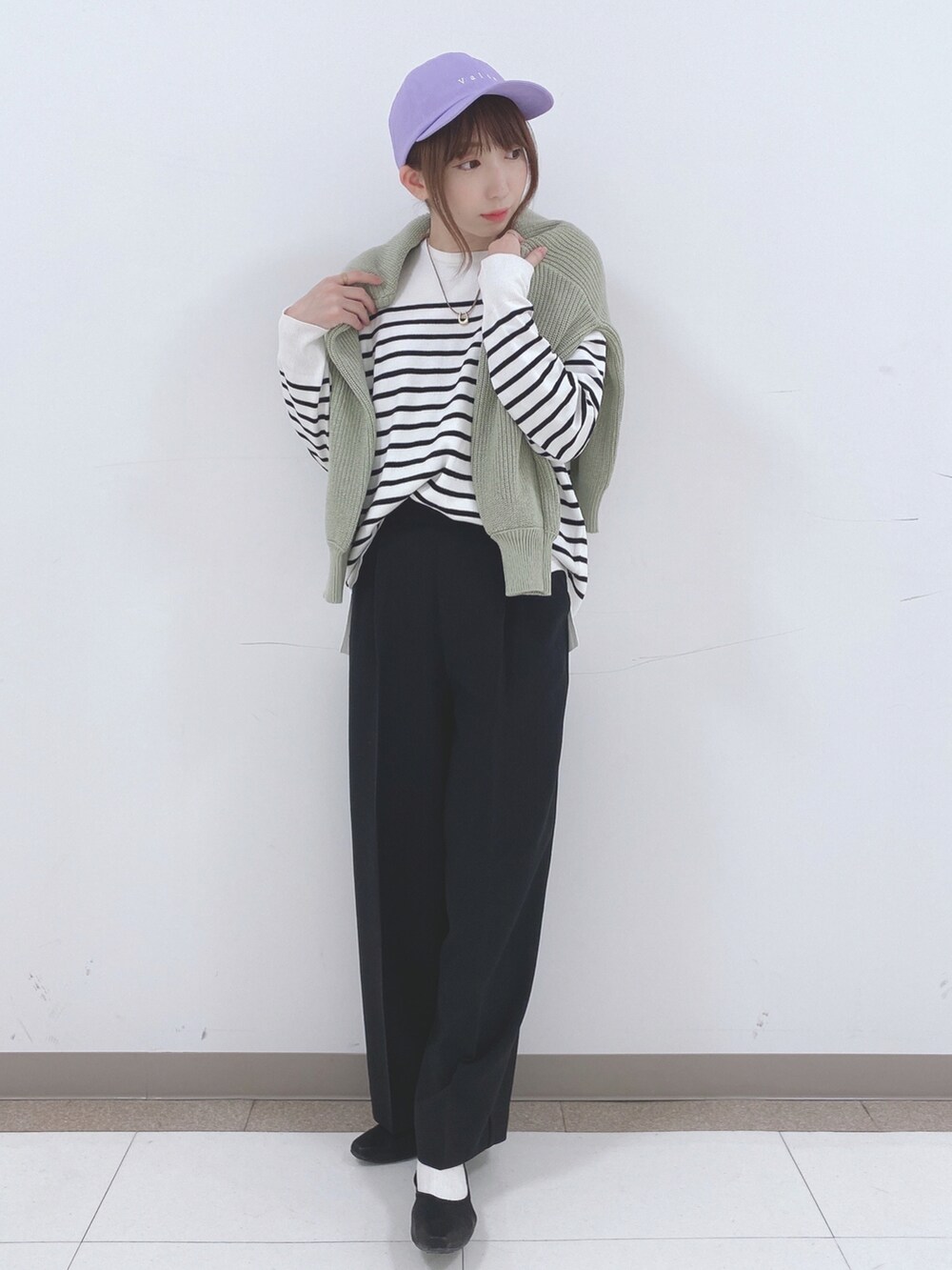 ブラック系のニット/セーター、グリーン系のカーディガン/ボレロ、ブラック系のその他パンツを着用したレディースの春コーディネートの4枚目の写真