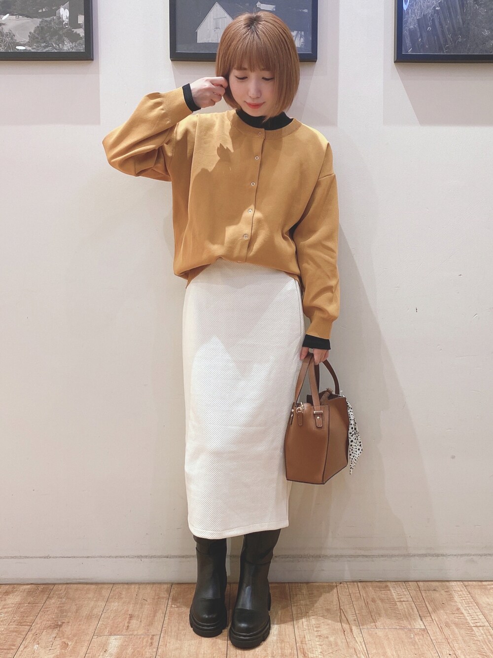 ブラック系のブーツ、イエロー系のカーディガン/ボレロ、ホワイト系のスカートを着用したレディースの秋コーディネートの4枚目の写真