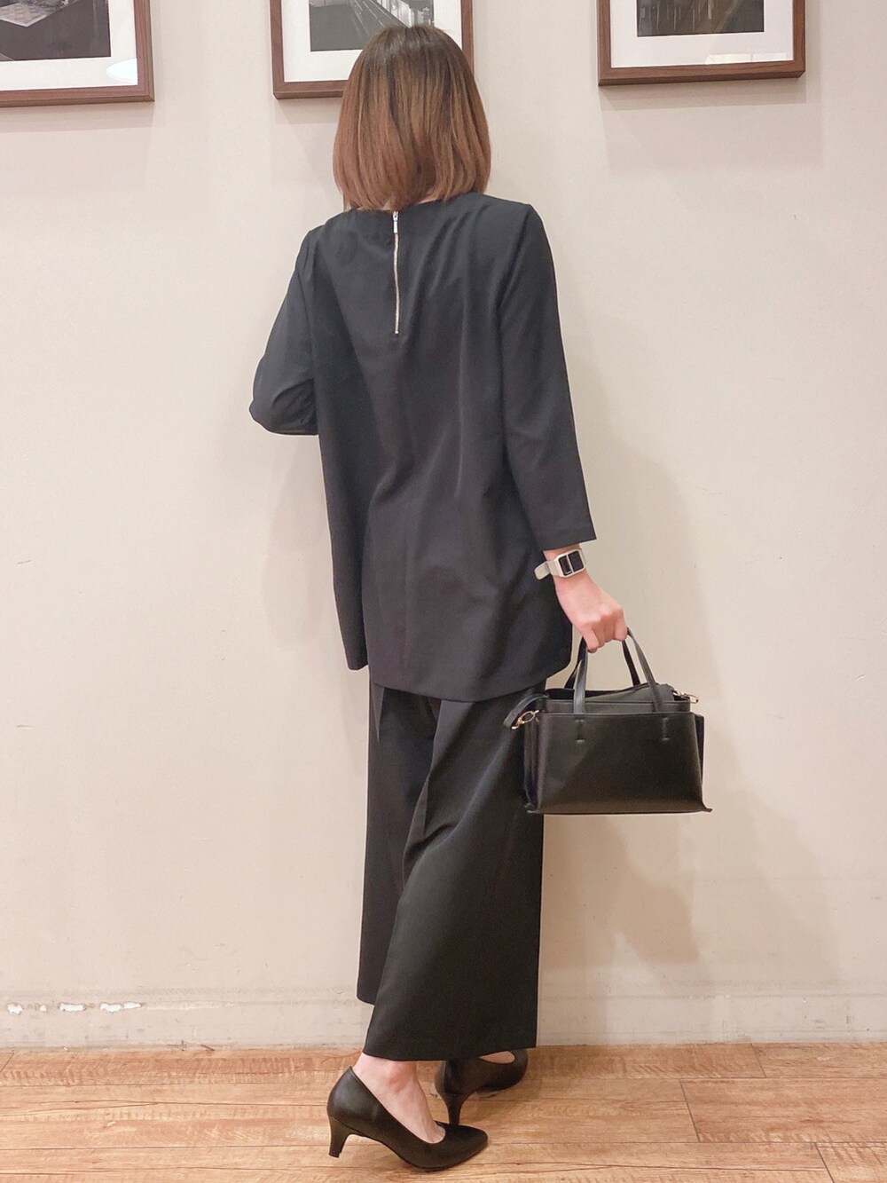 ブラック系のチュニック、ブラック系のその他パンツ、ブラック系のパンプスを着用したレディースの冬コーディネートの3枚目の写真