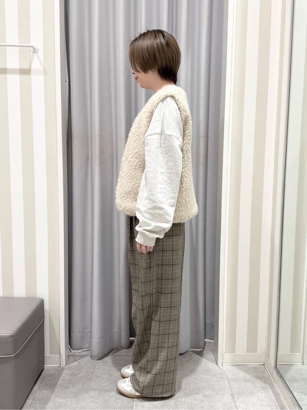 ベージュ系のベスト、ホワイト系のスウェット、ベージュ系のその他パンツを着用したレディースの秋コーディネートの2枚目の写真