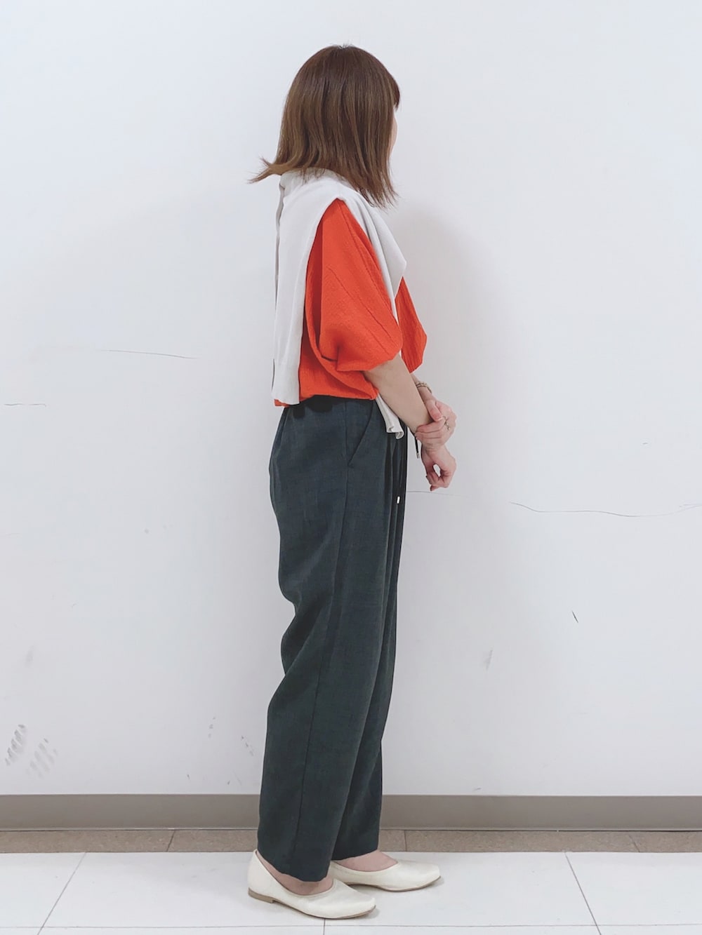グレー系のカーディガン/ボレロ、オレンジ系のシャツ/ブラウス、グレー系のその他パンツを着用したレディースの春コーディネートの2枚目の写真