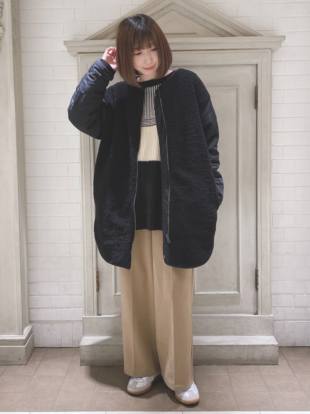 ブラック系のノーカラージャケット、ブラック系のニット/セーター、ベージュ系のその他パンツを着用したレディースの冬コーディネートの4枚目の写真