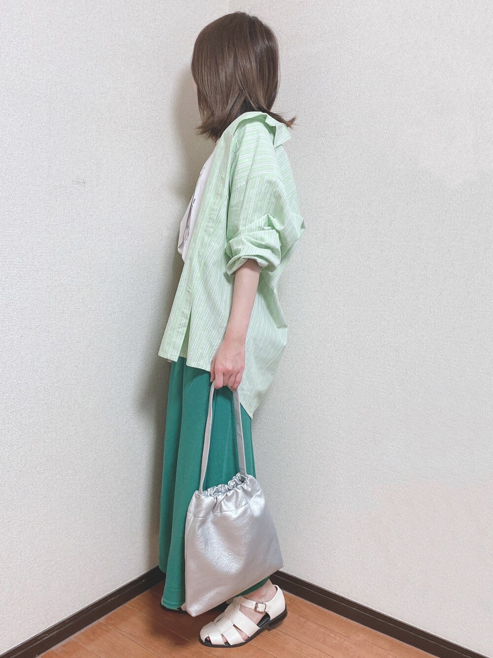 ホワイト系のTシャツ/カットソー、グリーン系のスカート、グリーン系のシャツ/ブラウスを着用したレディースの春コーディネートの2枚目の写真