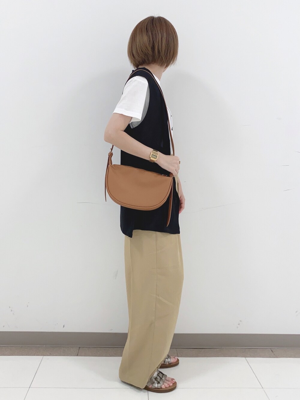 ブラック系のベスト、ベージュ系のその他パンツ、その他のサンダルを着用したレディースの夏コーディネートの2枚目の写真