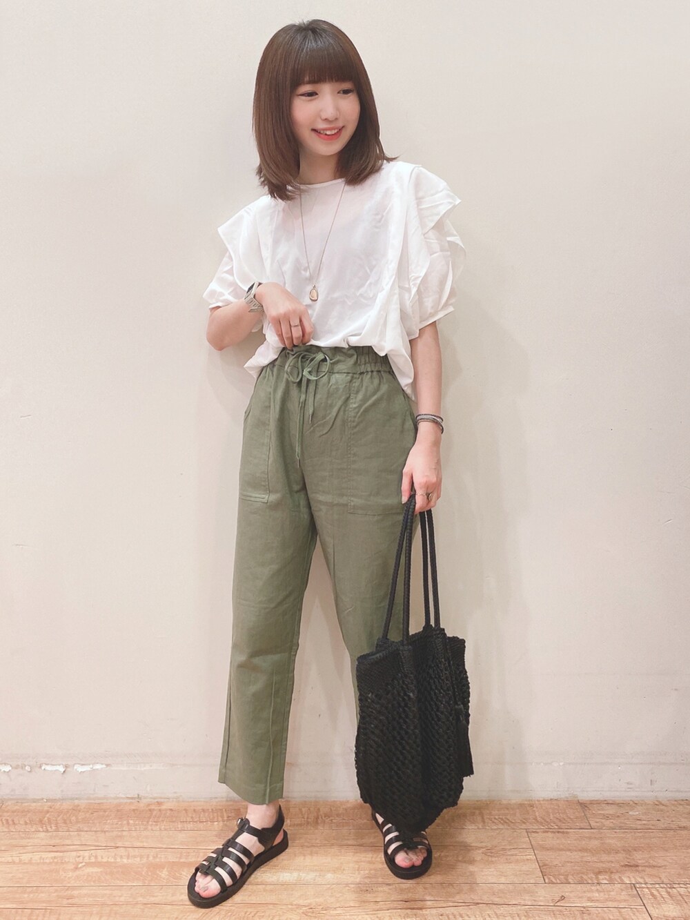 ホワイト系のシャツ/ブラウス、グリーン系のその他パンツ、ブラック系のサンダルを着用したレディースの春コーディネートの4枚目の写真