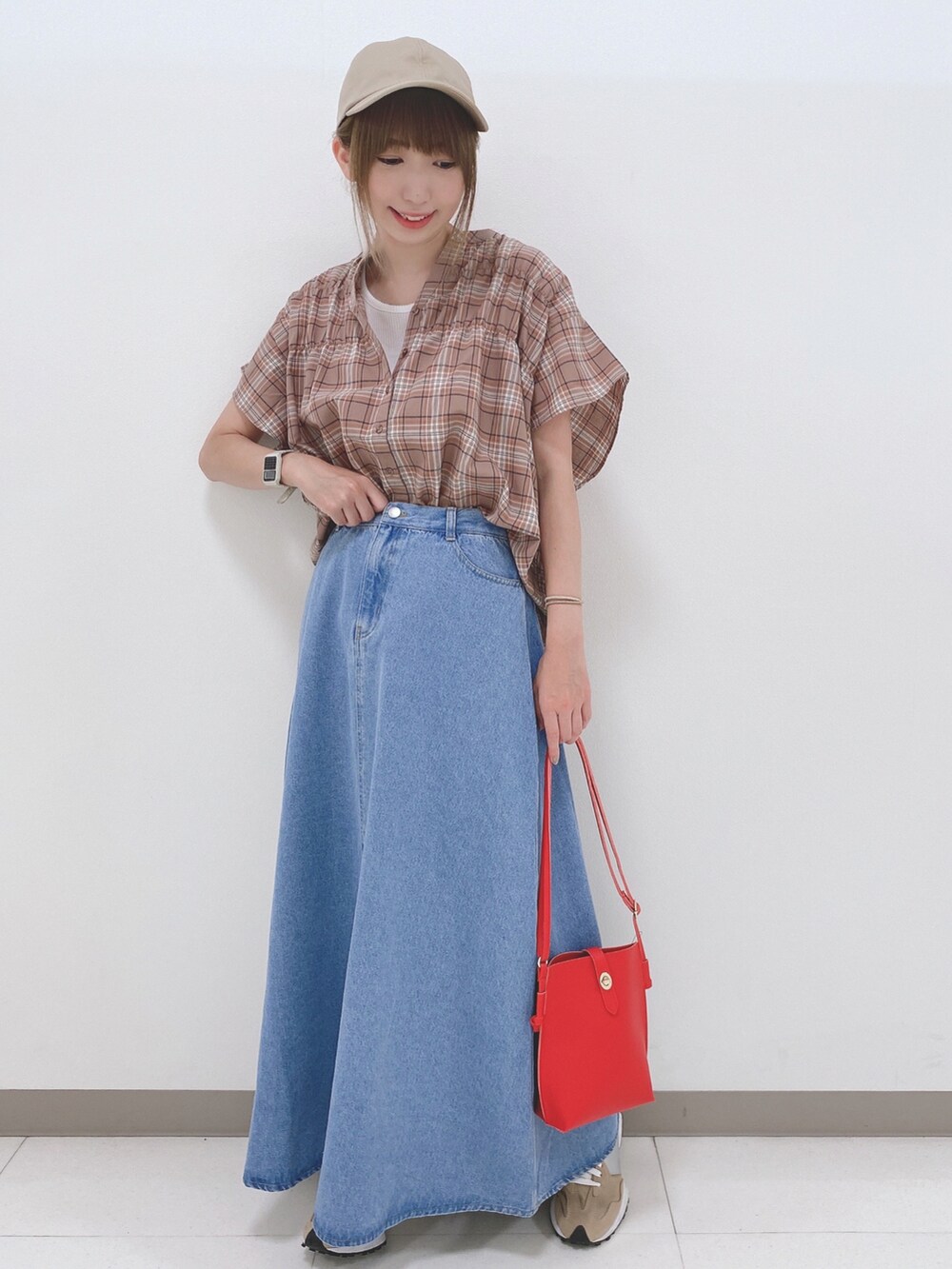 ベージュ系のシャツ/ブラウス、ブルー系のスカート、ベージュ系のスニーカーを着用したレディースの夏コーディネートの4枚目の写真