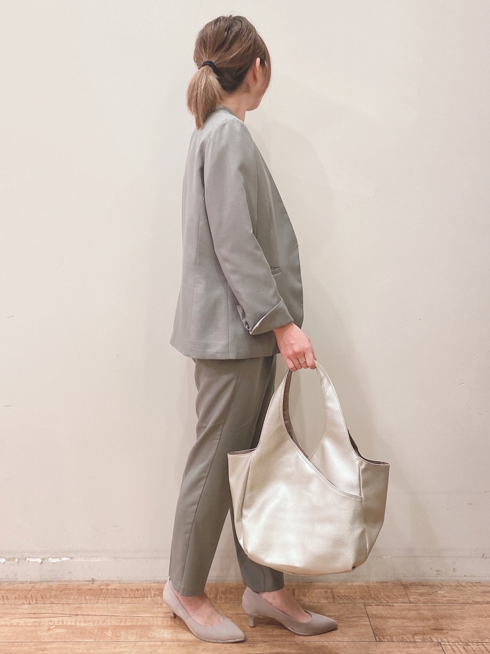 ホワイト系のタンクトップ、グリーン系のノーカラージャケット、ベージュ系のパンプスを着用したレディースの春コーディネートの2枚目の写真