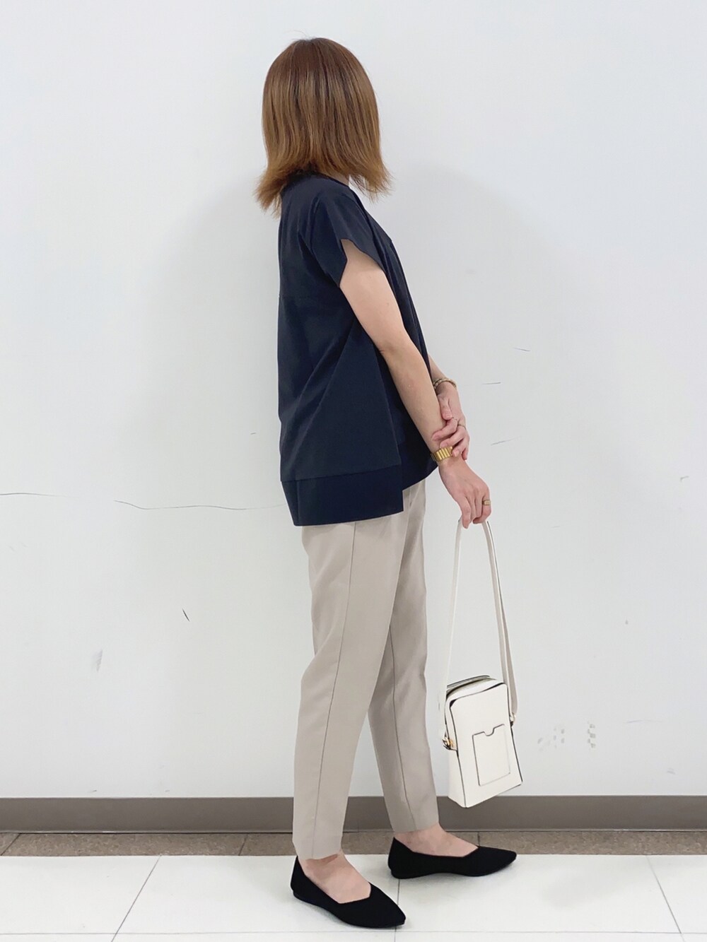 ホワイト系のTシャツ/カットソー、ベージュ系のその他パンツ、ホワイト系のショルダーバッグを着用したレディースの春コーディネートの2枚目の写真