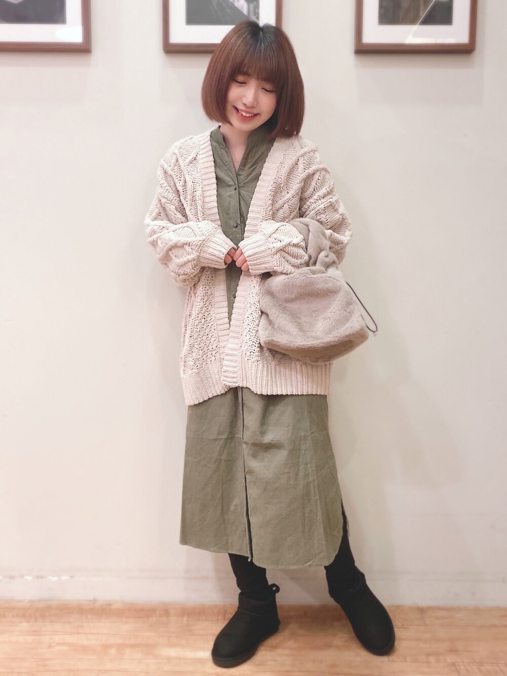 ホワイト系のカーディガン/ボレロ、グリーン系のワンピース、ブラウン系のショルダーバッグを着用したレディースの秋コーディネートの2枚目の写真