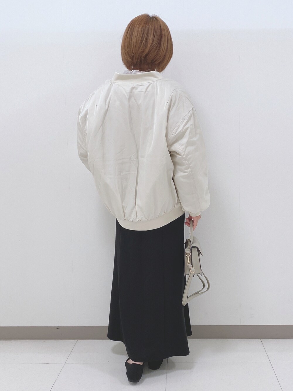 ベージュ系のブルゾン、ブラック系のニット/セーター、ホワイト系のTシャツ/カットソーを着用したレディースの秋コーディネートの3枚目の写真