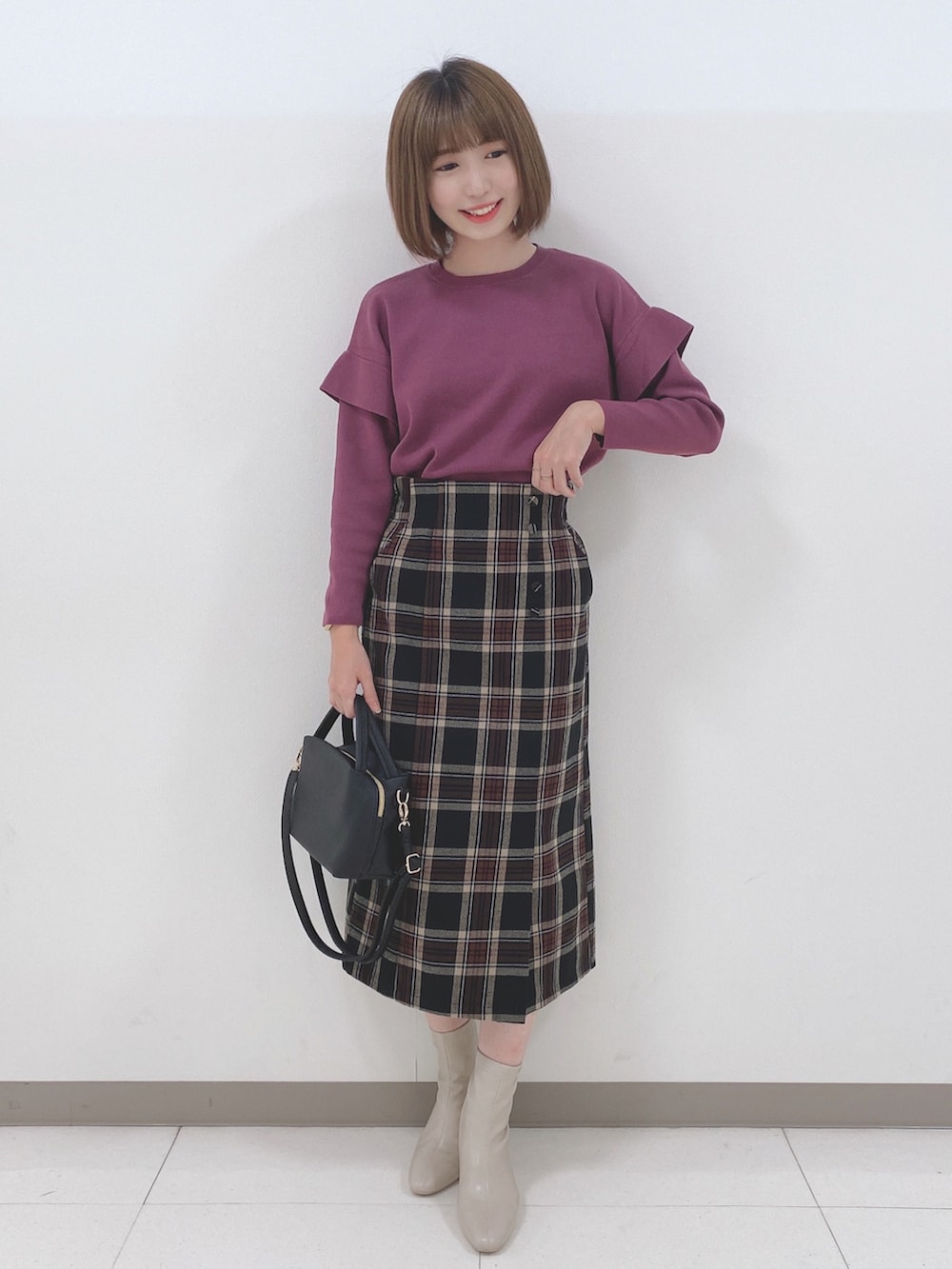 ピンク系のニット/セーター、ブラック系のスカート、ホワイト系のブーツを着用したレディースの秋コーディネートの4枚目の写真