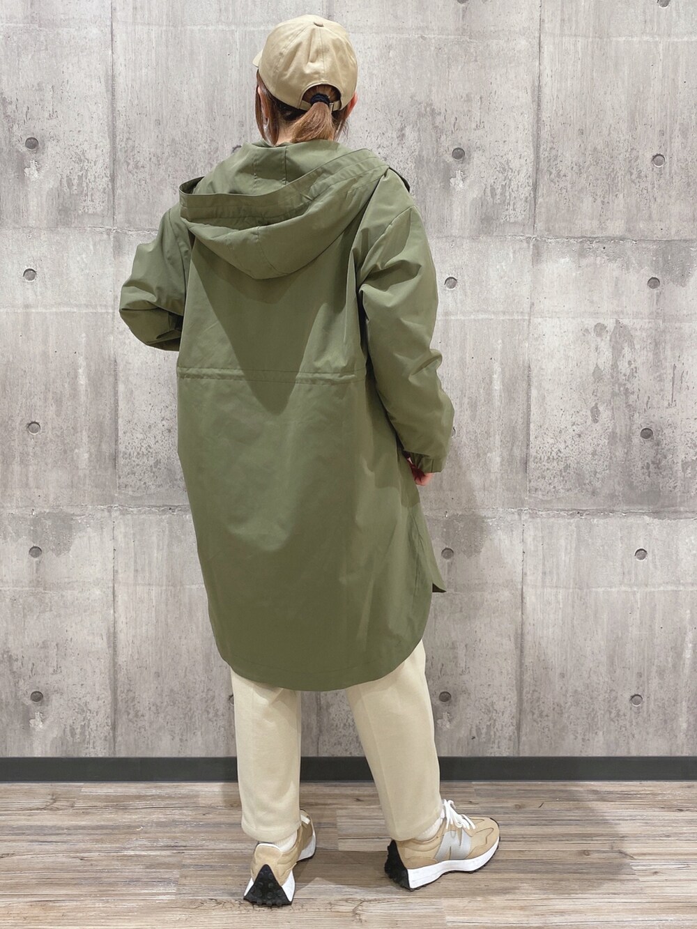 グレー系のスウェット、グリーン系のモッズコート、ホワイト系のその他パンツを着用したレディースの冬コーディネートの2枚目の写真