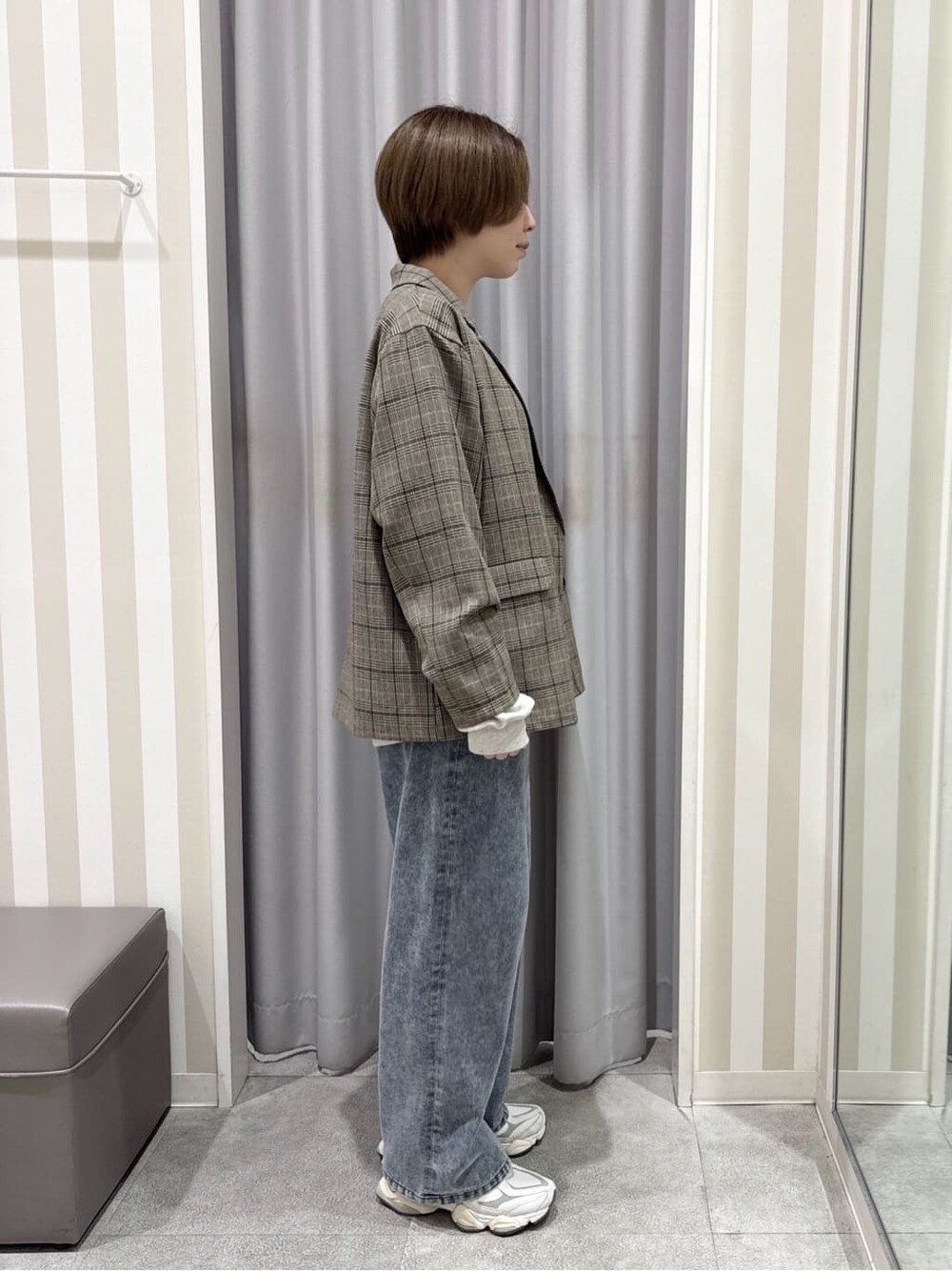 ベージュ系のテーラードジャケット、ホワイト系のスウェット、ブルー系のデニムパンツを着用したレディースの秋コーディネートの2枚目の写真