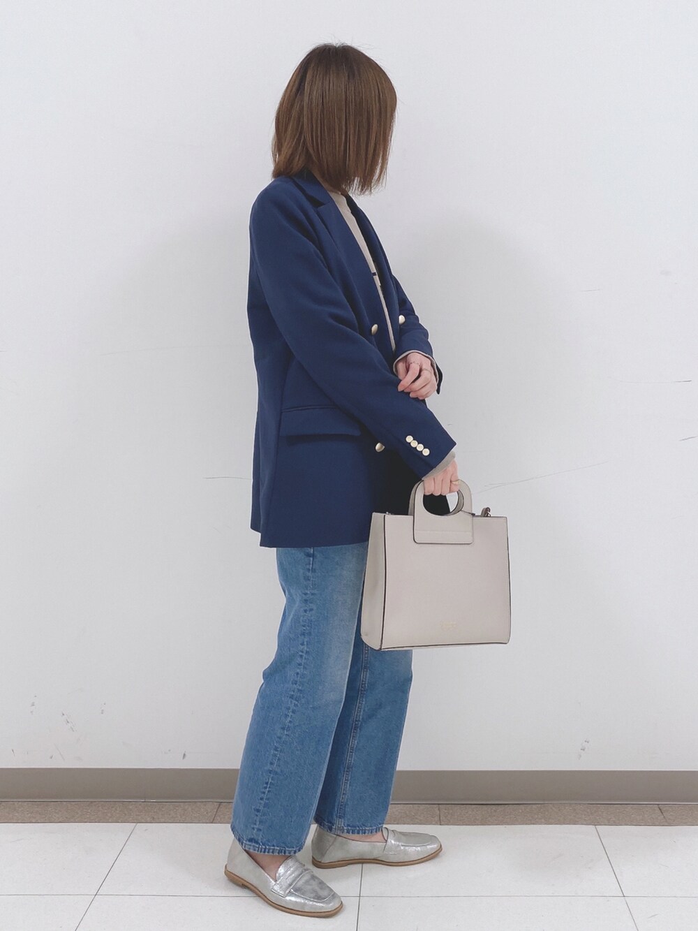 ベージュ系のニット/セーター、ブルー系のテーラードジャケット、ブルー系のデニムパンツを着用したレディースの冬コーディネートの2枚目の写真