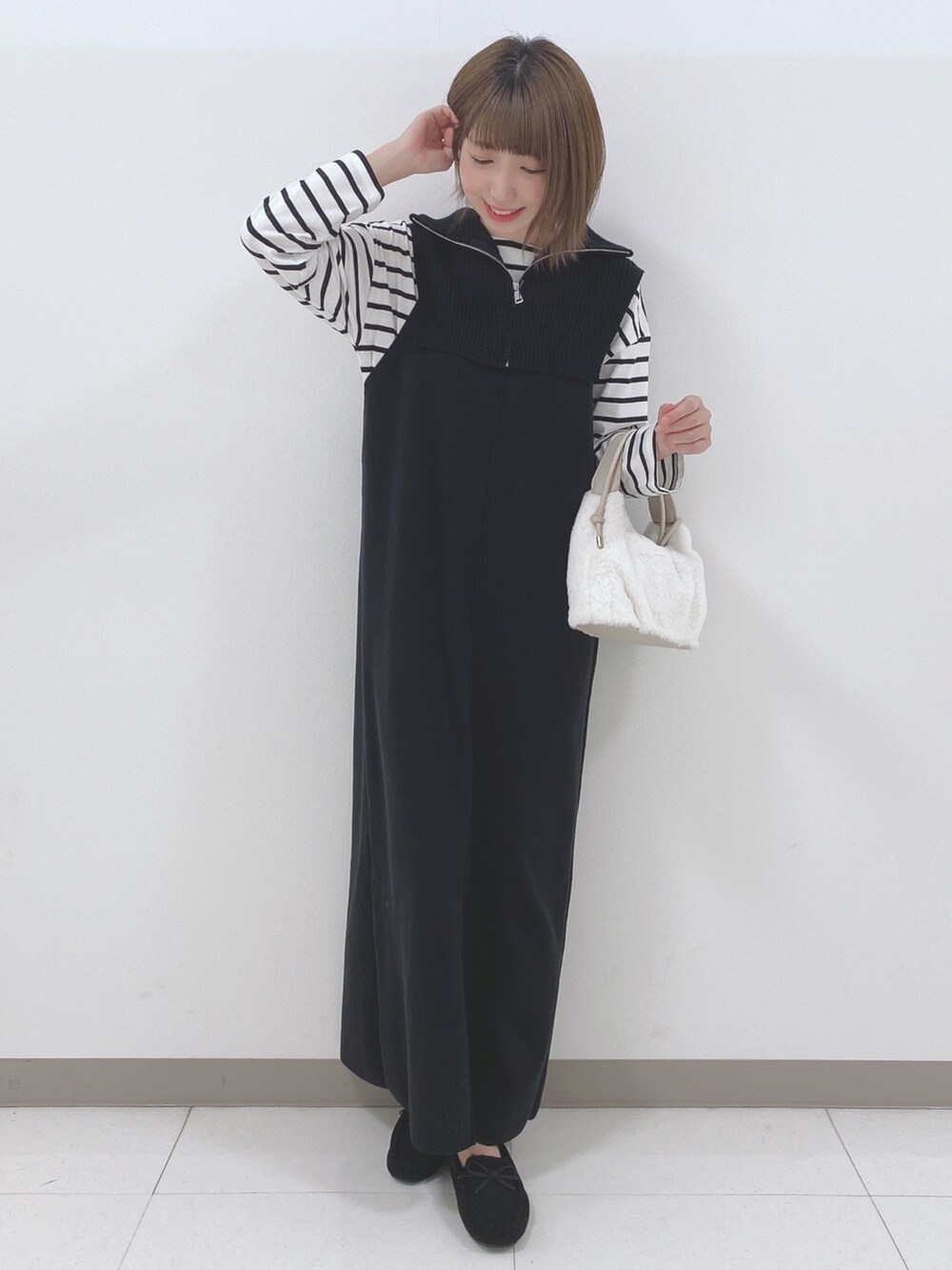 ブラック系のワンピース、ホワイト系のTシャツ/カットソー、ホワイト系のショルダーバッグを着用したレディースの秋コーディネートの4枚目の写真