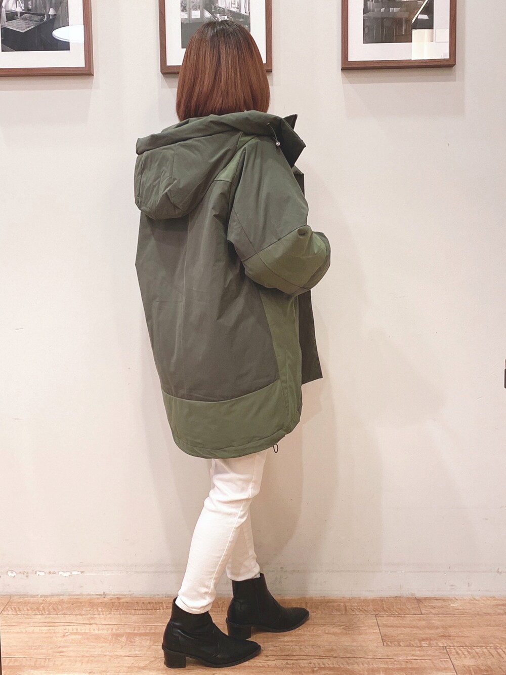 グリーン系のその他アウター、ブラック系のニット/セーター、ホワイト系のデニムパンツを着用したレディースの冬コーディネートの3枚目の写真