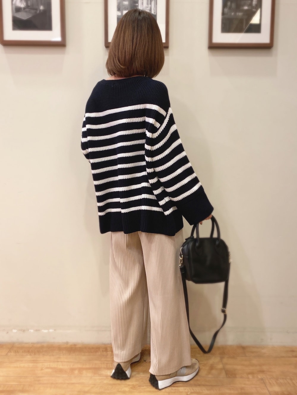 ブルー系のニット/セーター、ブラック系のショルダーバッグ、ベージュ系のスニーカーを着用したレディースの冬コーディネートの2枚目の写真