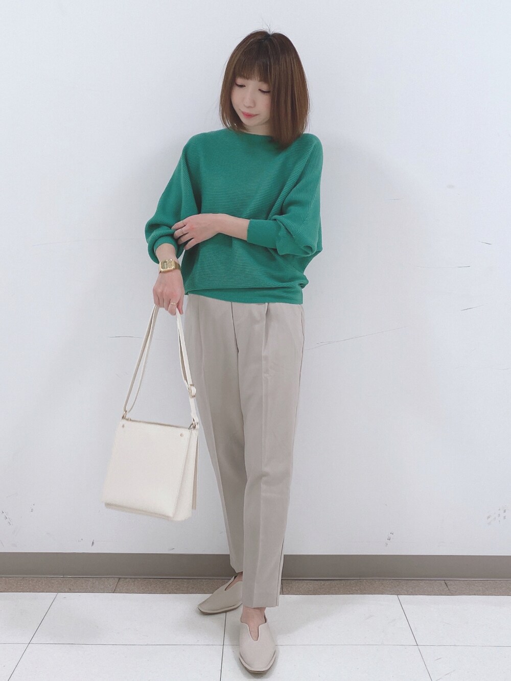 グリーン系のニット/セーター、ベージュ系のその他パンツ、ホワイト系のパンプスを着用したレディースの冬コーディネートの4枚目の写真