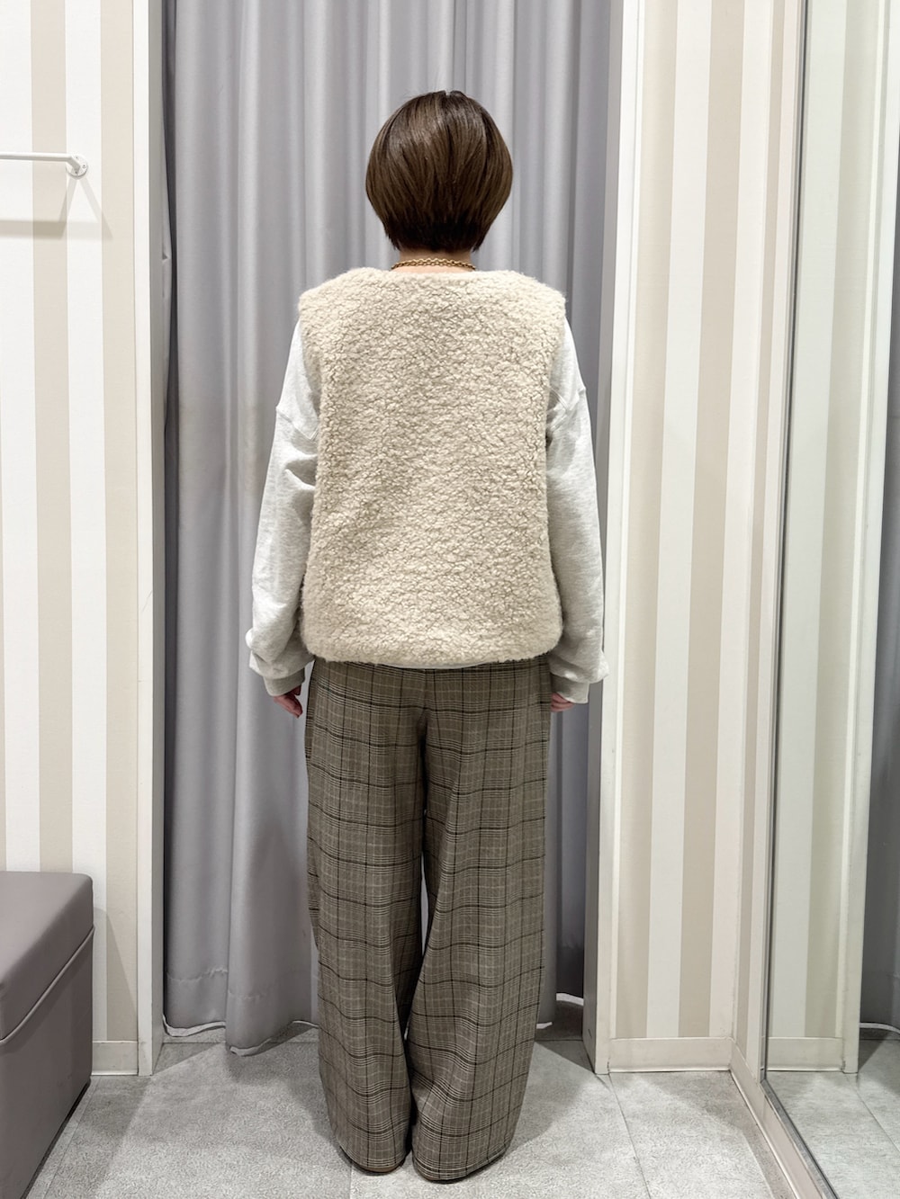 ホワイト系のスウェット、ベージュ系のベスト、ベージュ系のその他パンツを着用したレディースの秋コーディネートの3枚目の写真